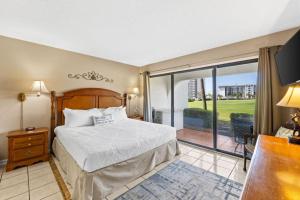 a bedroom with a bed and a sliding glass door at Edgewater Golf Villa 605 in Panama City Beach