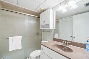 a bathroom with a sink and a toilet and a mirror at Edgewater Golf Villa 605 in Panama City Beach +30 photos