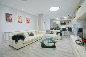 a living room with two white couches and a table at Apartamento Lagun Concha Beach in San Sebastián