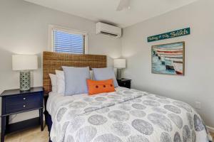 a bedroom with a bed with an orange pillow on it at South Beach Cabana Up (Private Front Deck, Pool, Steps from the Beach) in Fernandina Beach
