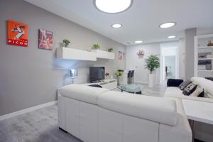 una sala de estar blanca con un gran sofá blanco en Apartamento Lagun Concha Beach, en San Sebastián