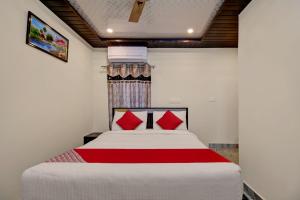 um quarto com uma cama grande e almofadas vermelhas em OYO Hotel SSD Grand em Pūdimadaka