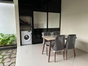 a dining room table with chairs and a washing machine at Villa Medea Banyuwangi in Banyuwangi