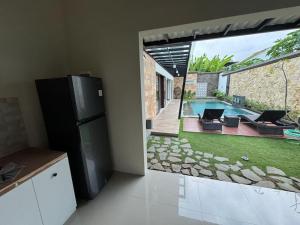 a kitchen with a view of a backyard with a pool at Villa Medea Banyuwangi in Banyuwangi