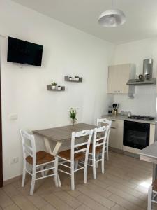 Giardina Gallotti的住宿－La Finestrella，厨房配有木桌和椅子