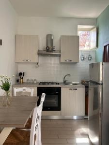 cocina con mesa de madera y electrodomésticos de acero inoxidable en La Finestrella, en Giardina Gallotti