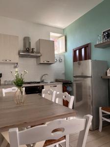 Giardina Gallotti的住宿－La Finestrella，厨房配有桌子和不锈钢冰箱。