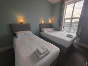 2 camas en una habitación con ventana en Station View Tavern, en Cork