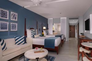 a hotel room with a bed and a living room at Secrets St. James in Montego Bay