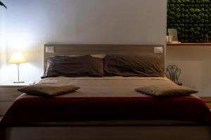 a bed with two pillows on it in a bedroom at L'ombelico del Monte - appartamenti in centro storico in Piazza Armerina