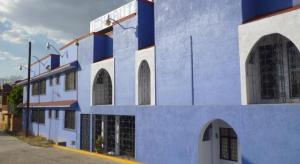 a blue and white building with arched windows at Hotel Huautla de Oaxaca in Oaxaca City