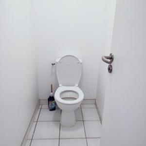 a white bathroom with a toilet in a stall at Grand appartement de 3 chambres moderne et spacieux, entièrement meublé in Belfort