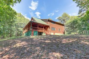 a house on top of a hill with trees at Rogers Cabin on 17 Acres with Wraparound Deck! in Rambo Riviera