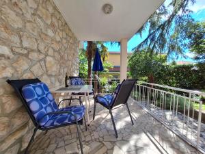 een patio met stoelen en een tafel op een balkon bij Apartments Danica in Dramalj