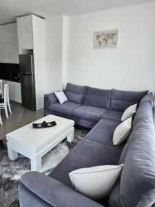 Una sala de estar con un sofá azul y una mesa. en Luxury Apartment Hannah, en Vlorë 7 fotos más