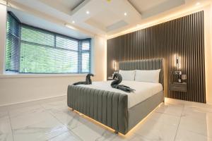 OYO Bellevue Apartments Middlesborough في ميدلسبرو: غرفة نوم بسرير كبير عليها بجعات