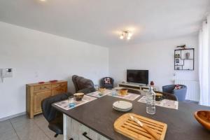 ein Wohnzimmer mit Tisch und Stühlen und einem Fernseher in der Unterkunft Beautiful apartment with terrace Annecy in Annecy