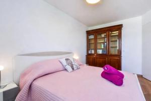 ein Schlafzimmer mit einem rosa Bett mit lila Kissen in der Unterkunft Beautiful apartment with terrace Annecy in Annecy