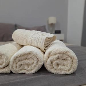 una pila de toallas sentadas encima de una cama en Hotel Los Angeles en Santa Teresita