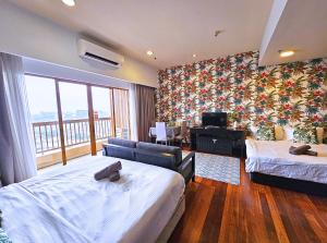 a hotel room with two beds and a balcony at Sunway Studio Homestay with Balcony Theme Park View Connecting Sunway Pyramid Mall & Sunway Lagoon in Petaling Jaya