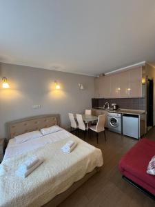 une chambre avec un lit et une cuisine avec une table dans l'établissement Apart Hotel Black Sea Towers, à Batoumi