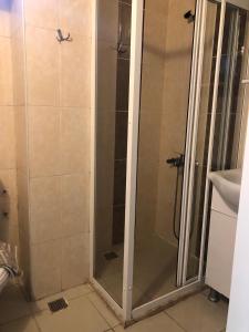 een douche met een glazen deur in de badkamer bij MİNA GRAND HOTEL in Kemer