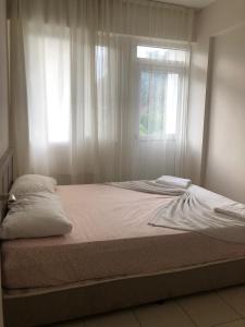 Bett in einem Schlafzimmer mit Fenster in der Unterkunft MİNA GRAND HOTEL in Kemer