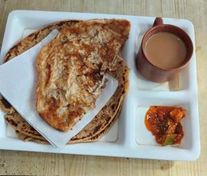 un piatto di cibo con pane tostato e una tazza di caffè di Hotel Laxmi Guest House Jadavpur - Excellent Service a Calcutta