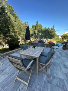 a table and chairs and an umbrella on a patio at Apartment Nika in Starigrad-Paklenica +8 photos