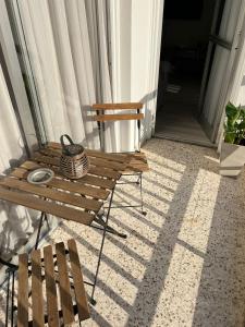 a wooden bench and a table on a porch at Cozy Apartment by the sea in Limassol