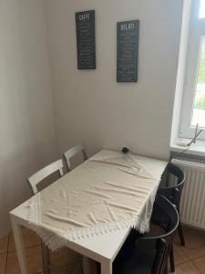 a white table and chairs with a white tablecloth on it at Apartmán Papoušek in Znojmo