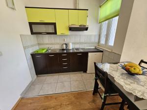 a kitchen with yellow cabinets and a table with bananas on it at Studio apartment in Duce with sea view, balcony, air conditioning, WiFi 5067-6 in Duće +22 photos