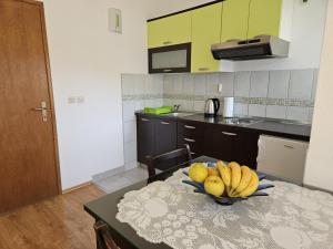 a kitchen with a table with a bowl of fruit on it at Studio apartment in Duce with sea view, balcony, air conditioning, WiFi 5067-6 in Duće