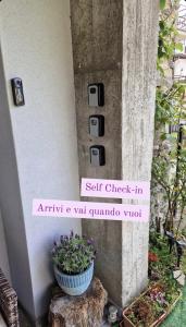 a sign that says self check in at entry and yet guzmania vitt at CASA BAT in Mantello