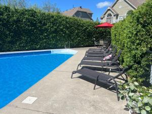 una fila de tumbonas junto a una piscina en Chalet Saint-Sauveur with heated pool!, en Saint-Sauveur-des-Monts