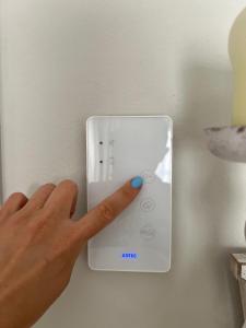 a person pressing a button with their finger on a lightswitch at Cozy Apartment by the sea in Limassol