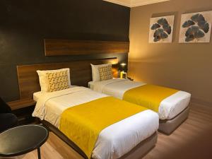 Habitación de hotel con 2 camas con sábanas amarillas en Yto boutique Hotel, en Casablanca