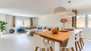 a kitchen and living room with a wooden table and chairs at Apartment Alice in Port de Pollensa
