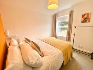 a bedroom with a bed with pillows and a window at Stylish 5 Beds House, TV, Garden in Rushden