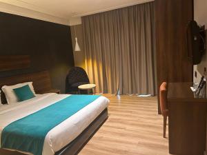 um quarto de hotel com uma cama grande e uma secretária em Yto boutique Hotel em Casablanca