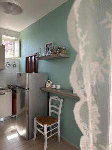 Giardina Gallotti的住宿－La Finestrella，厨房配有冰箱和椅子