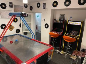 a room with a ping pong table and two video games at Backpackers Blackpool - Family Friendly Hotel in Blackpool