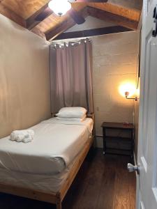 ein kleines Bett in einem Zimmer mit Holzdecke in der Unterkunft WILLIAMS AZ HOSTEL in Williams