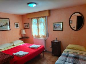 1 dormitorio con 2 camas y espejo en Il Cantinoccio B&B en Cerasolo