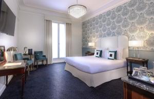 um quarto de hotel com uma cama e uma secretária em Hotel Claridge Paris em Paris