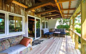 a porch with a couch and chairs on a house at Chata pod sosnami in Wilimy +2 photos