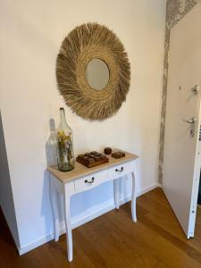a table with a mirror on the wall and a table with a bottle at Carreira Residence in Funchal