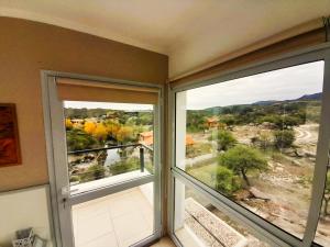 Habitación con 2 ventanas grandes con vistas. en Los Ancares Resort en Mina Clavero