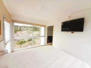a bedroom with a bed and a large window at Los Ancares Resort in Mina Clavero