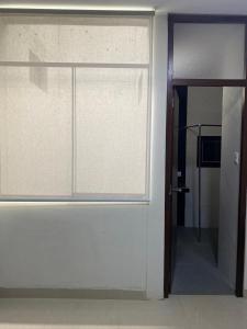 una puerta corredera de cristal con una ventana en una habitación en Edificio Casuarinas en Piura